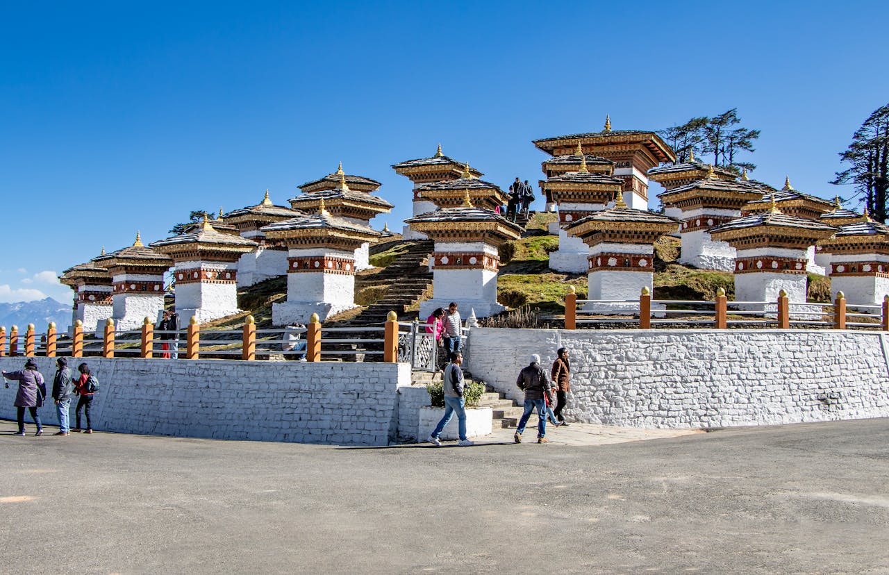 Scenic view of Dochula Pass featuring Druk Wangyal Chortens in Bhutan with tourists exploring.