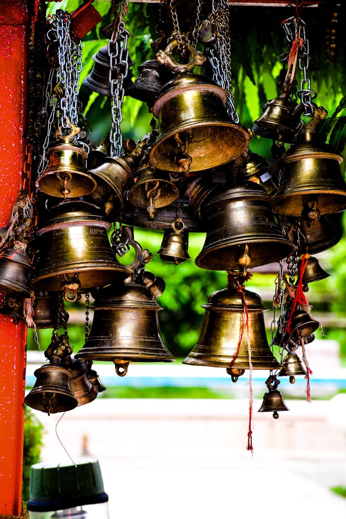 Cluster of hanging brass bells often seen in temples, symbolizing spirituality.