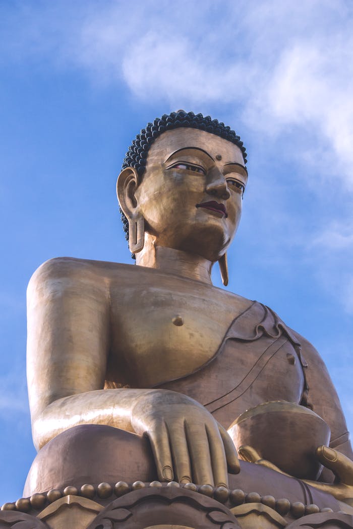 From below of huge bronze Buddha Dordenma statue situated in Bhutan against blue sky